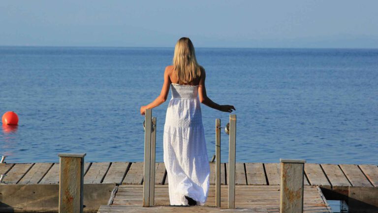 Tipps und Übungen für mehr Selbstfürsorge, Frau stehend am Meer