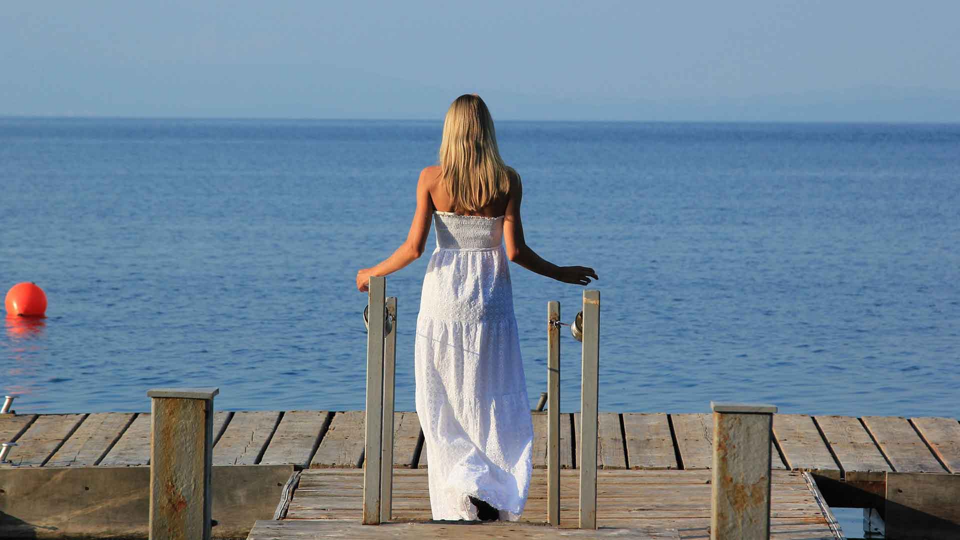 Tipps und Übungen für mehr Selbstfürsorge, Frau stehend am Meer
